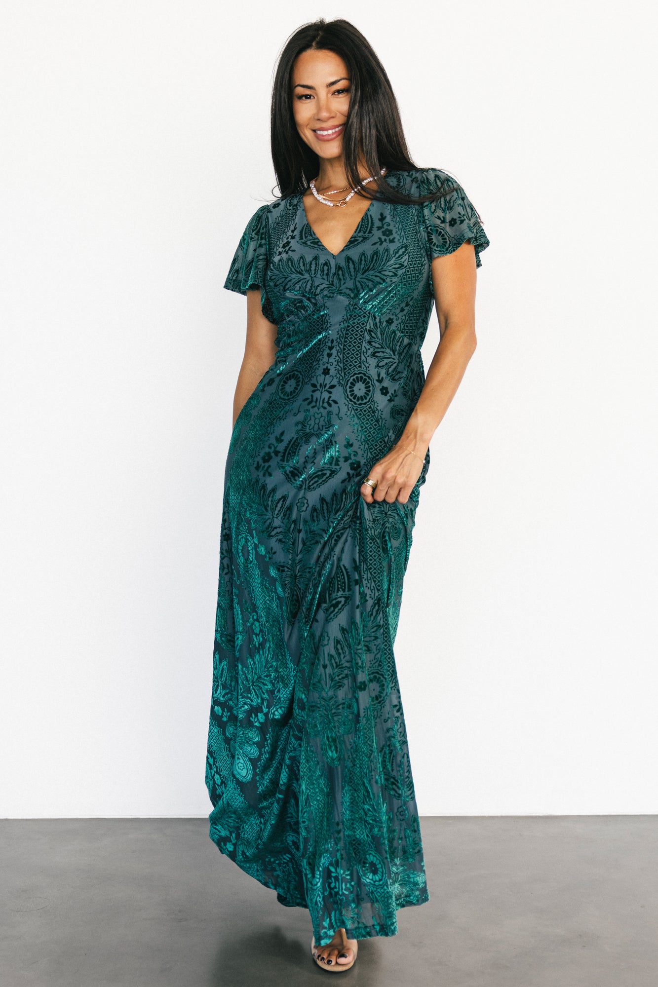 Styled outfit shot of the Kimberly emerald velvet burnout maxi dress paired with accessories, illustrating eveningwear styling options.