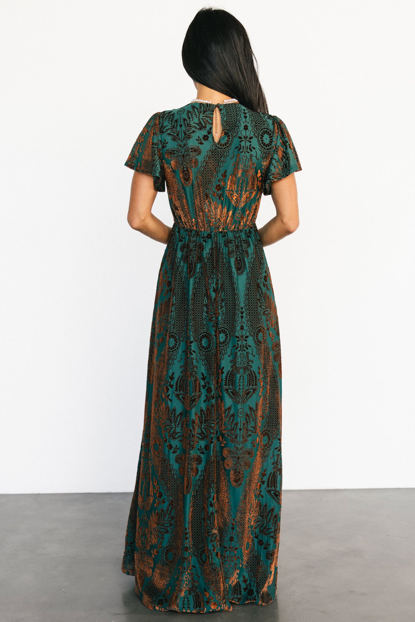 Detail view of the V-neckline and short flutter sleeve showing the unlined sheer sleeve and lined body construction.