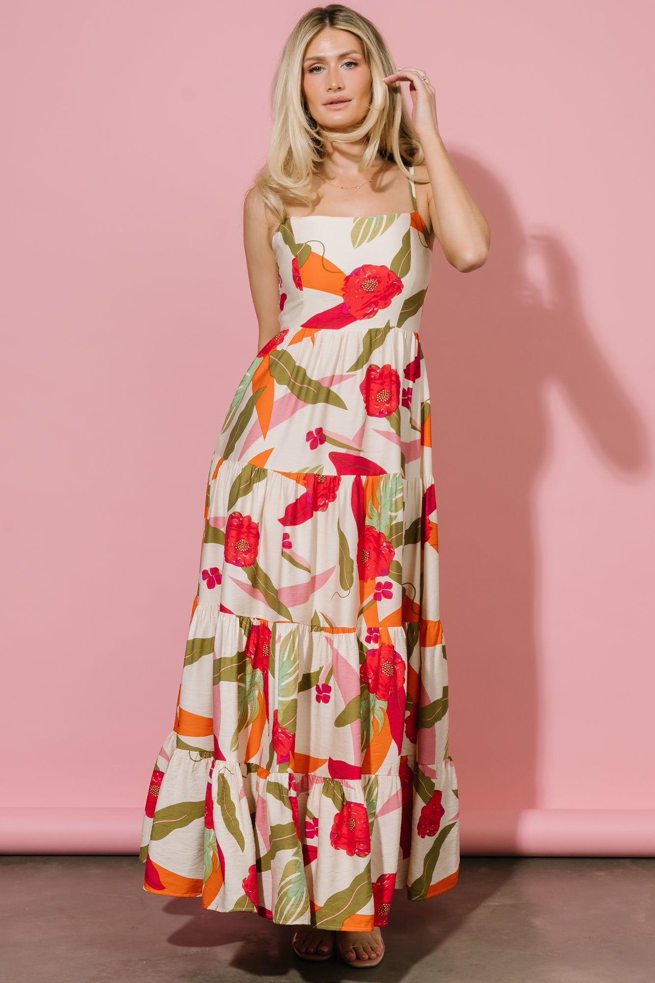 Close-up of textured rayon fabric with vibrant green, pink and orange abstract floral print and soft surface texture.