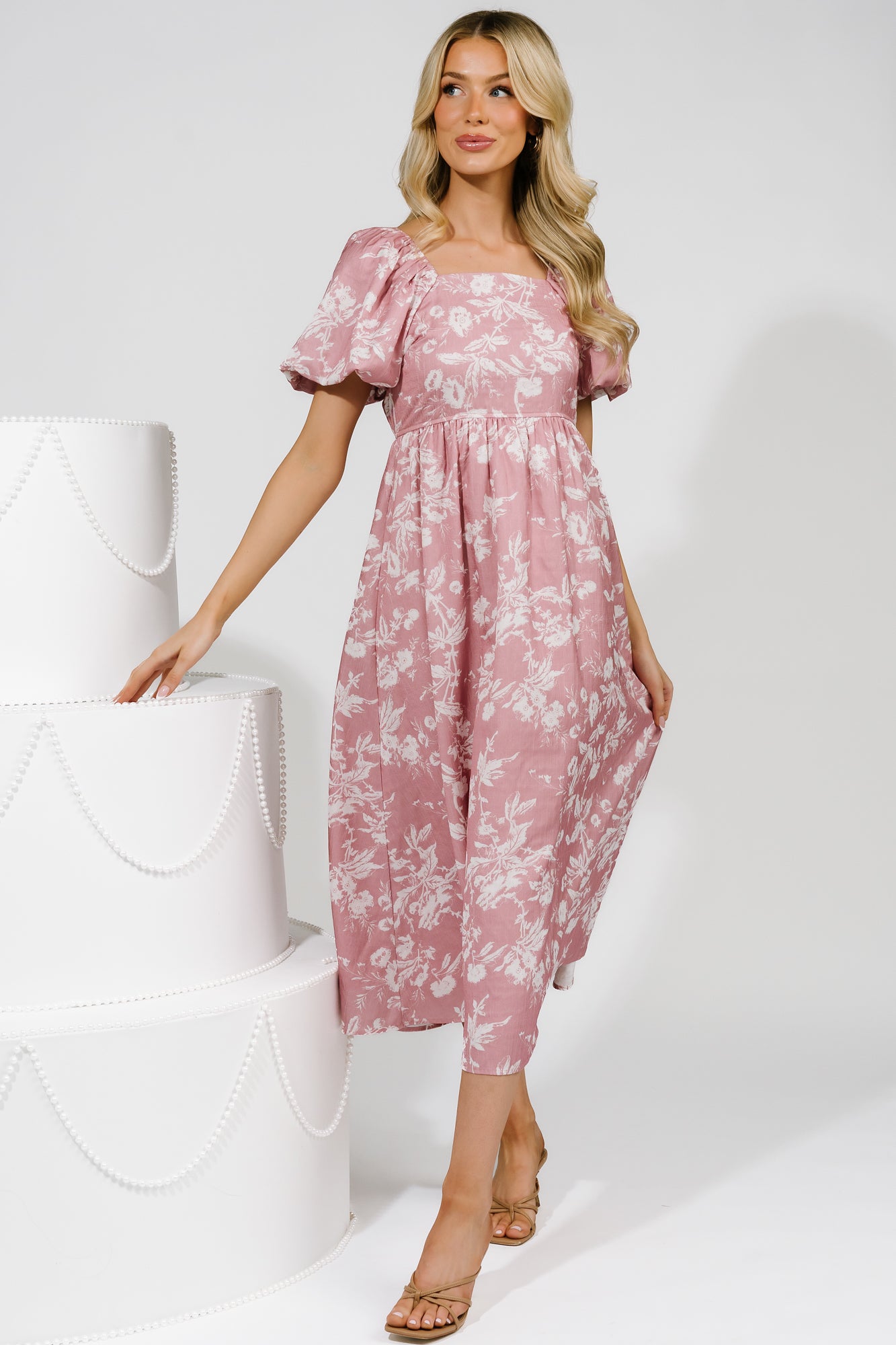 Side view highlighting hidden side pocket, high waist with elastic back, and smooth darted bodice of pink floral maxi dress.