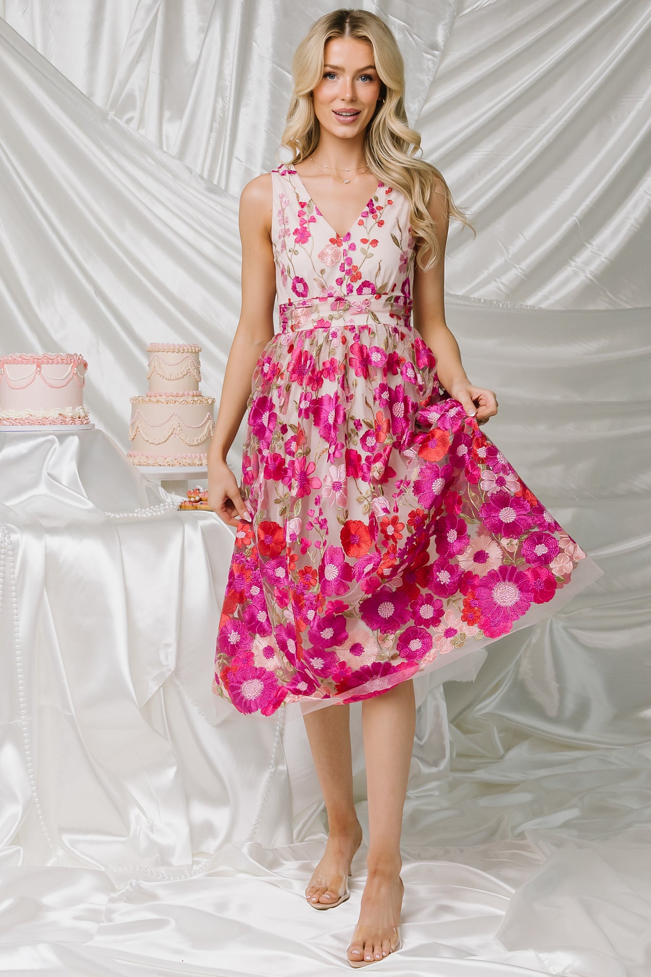 Close-up of embroidered tulle overlay showing multi-hue pink florals, textured stitching, and the soft sheer fabric layered over the lining.