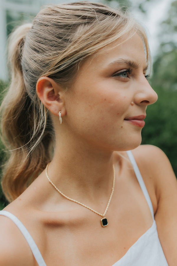 Close-up of Broadwater necklace with square Black Onyx set in a polished 18K gold-plated bezel on a twisted rope-style gold chain, neutral backdrop.