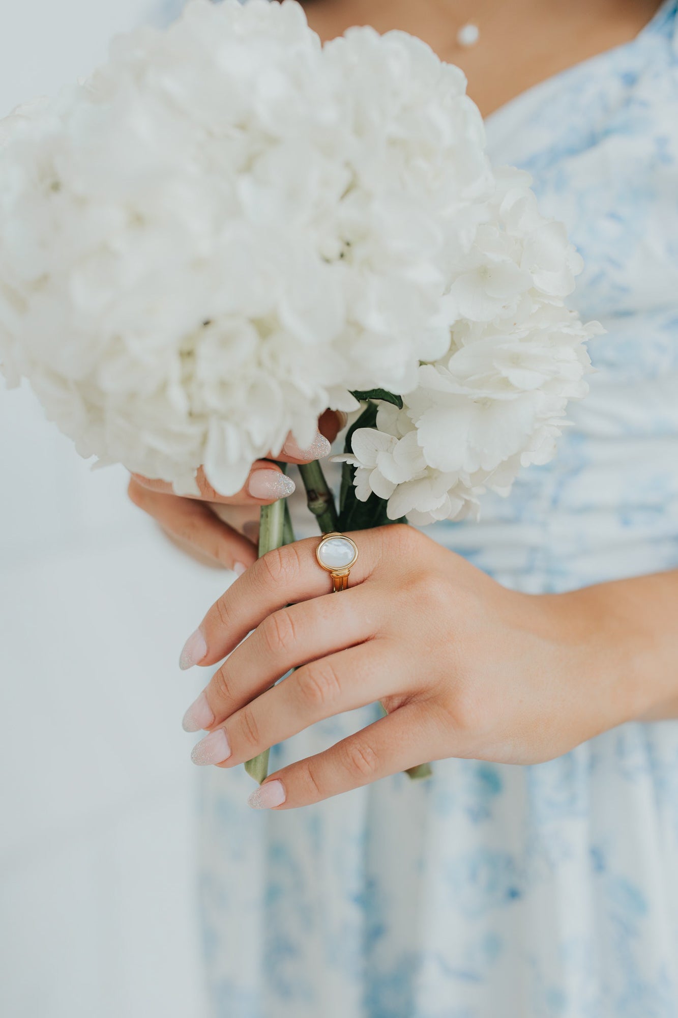 Angled product image of the Broadwater ring showcasing the oval mother-of-pearl and warm gold finish, suitable for both casual and formal styling.