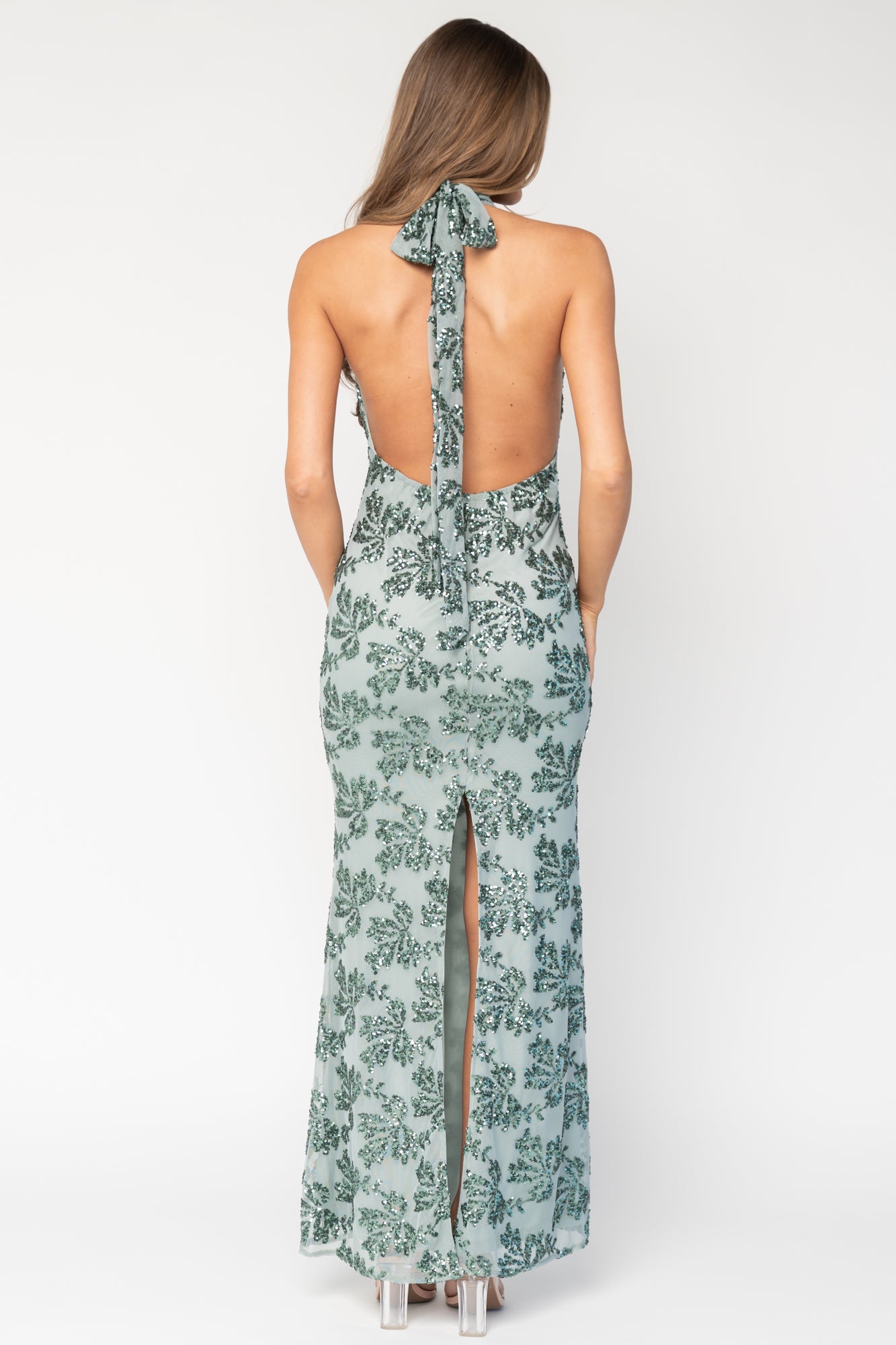 Detail shot of the sequined leaf pattern and hem edge, showing texture, shimmer, and the maxi-length drape on mesh fabric.