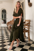 Close-up of smocked bodice and rounded V neckline on deep olive Lovell midi dress showing fabric texture and stitching detail.