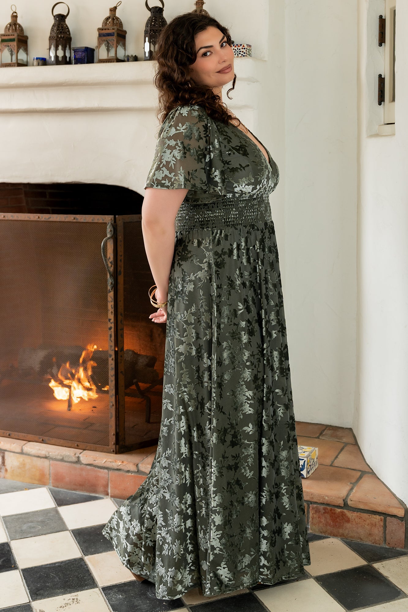 Model wearing the Veronica Velvet Maxi Dress in dark sage, demonstrating smocked waist fit, V-neckline, and maternity-friendly shape.
