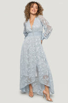 Back and side view of the Daniella dress highlighting the smocked waistband and movement of the high-low hem in burnout floral chiffon.