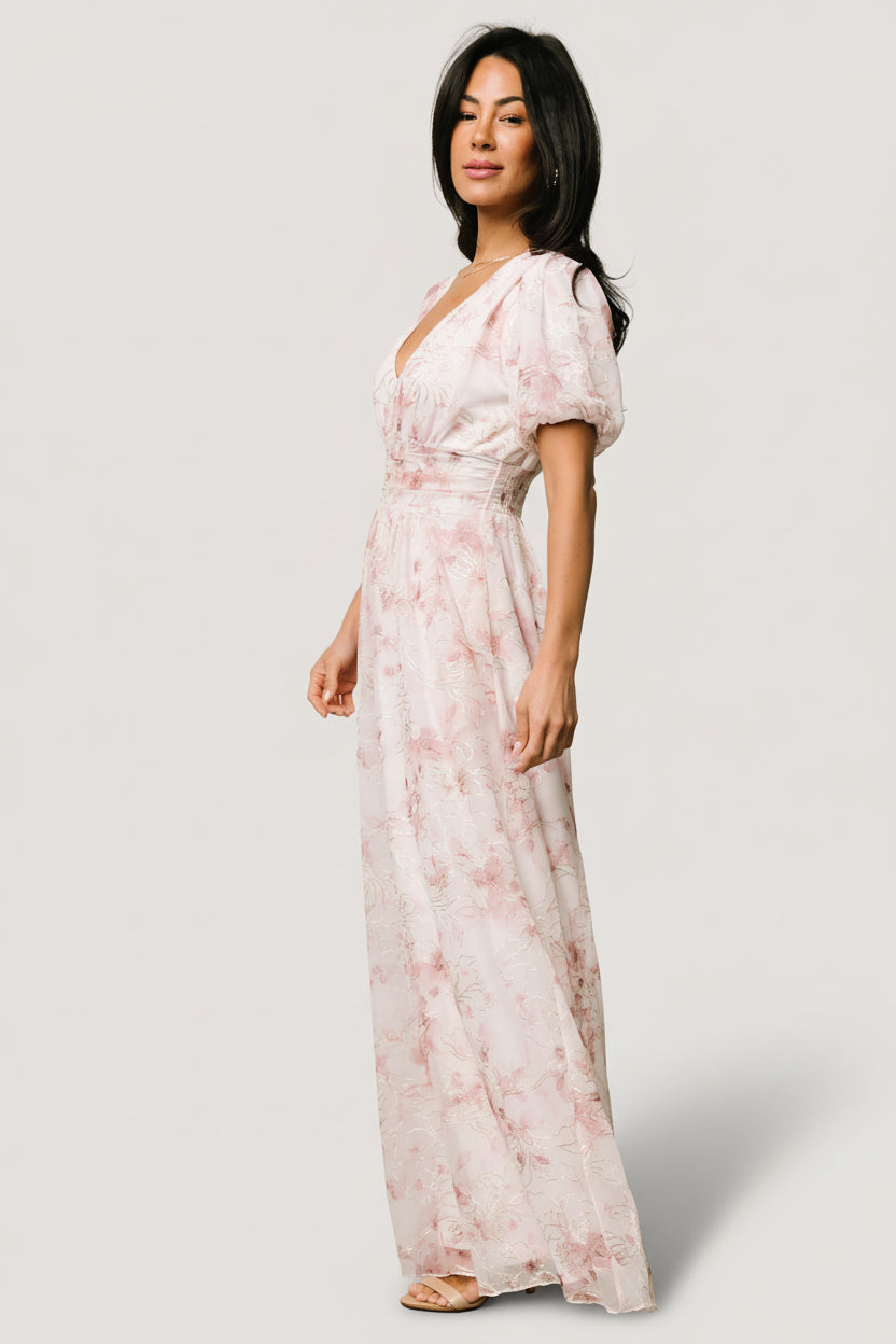 Side view of Ardley Maxi Dress displaying side pocket access, gathered waist fit, and embroidered floral detail along the skirt seam on model.
