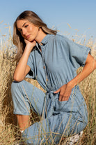 Side profile of Mateo jumpsuit on model, highlighting elastic waistband, removable self-tie sash, and belt loops.