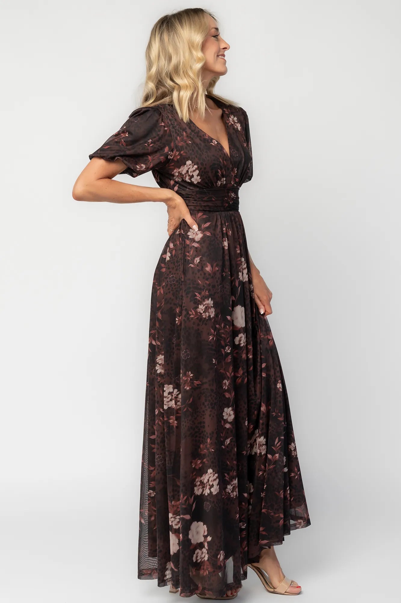 Model wearing a clove floral maxi dress with a deep V-neckline, short sleeves, and an empire waist.
