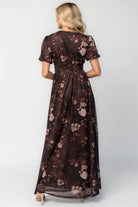 Model wearing a clove floral maxi dress with a deep V-neckline, short sleeves, and an empire waist.