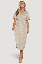 Model wearing Mayfair Sequin Midi Dress in champagne showing surplice neckline, short sleeves, and all-over silver sequins.