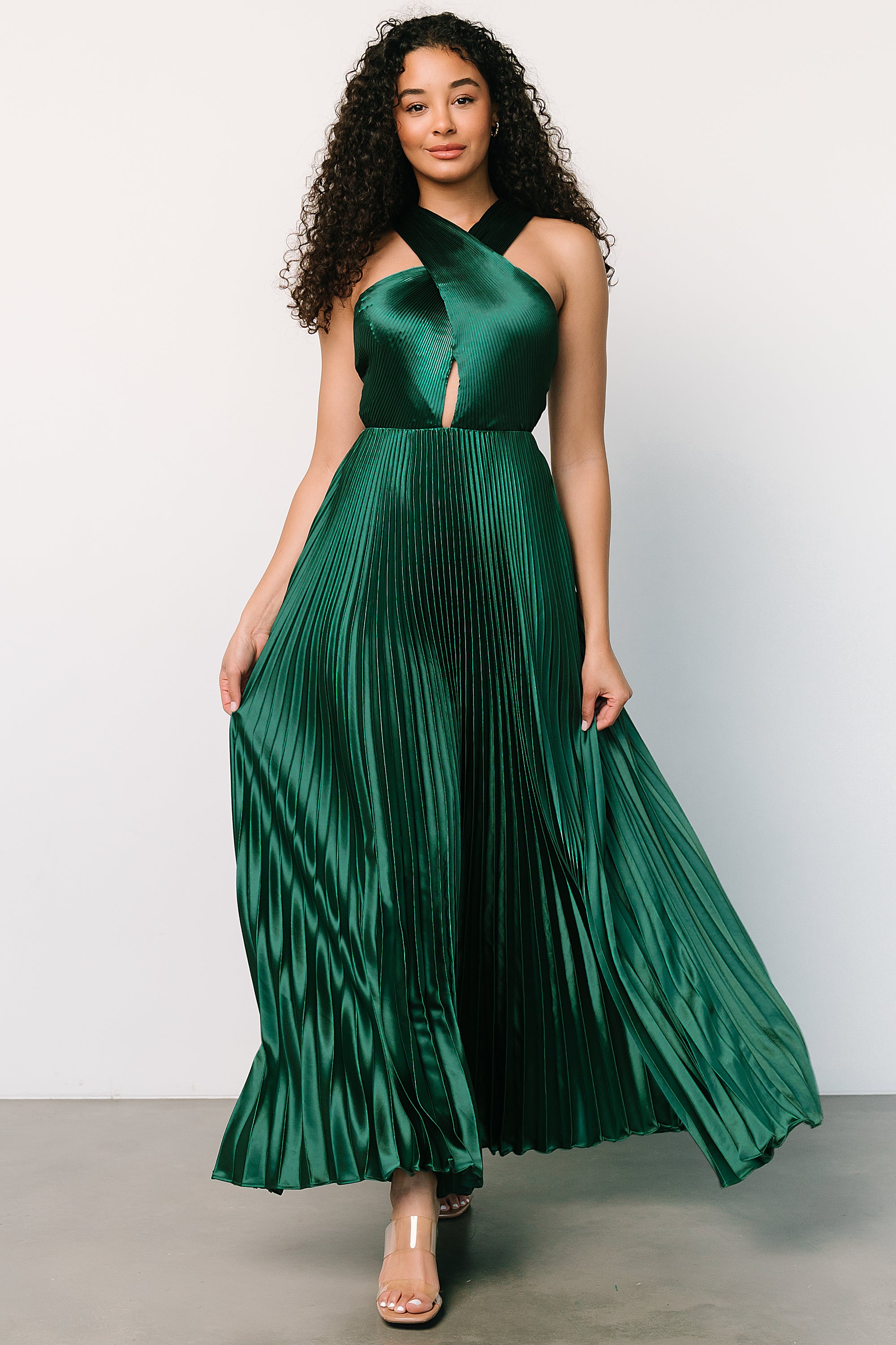 Close-up of the silky pleated fabric and keyhole bust detail on the emerald halter maxi, showing texture and stitched lined bodice.