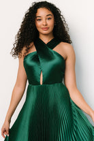 Full-length image of emerald pleated halter dress on a model, illustrating maxi hemline, pleat depth, and recommended fit for height reference.