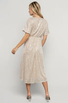 Back view showing rear silhouette, short sleeve coverage, and the lined midi skirt's graceful drape on the model.