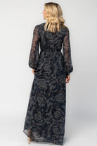 Model wearing a midnight blue floral maxi dress with a deep V-neckline and front tie keyhole detail.