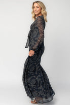Model wearing a midnight blue floral maxi dress with a deep V-neckline and front tie keyhole detail.