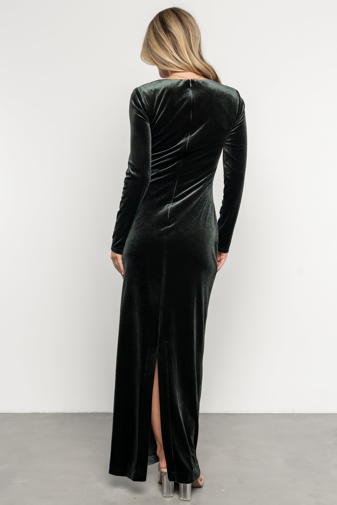 Back view of Kourtney velvet maxi dress in dark green showing discreet back slit, hidden zipper and flowing maxi hem.