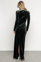 Back view of Kourtney velvet maxi dress in dark green showing discreet back slit, hidden zipper and flowing maxi hem.