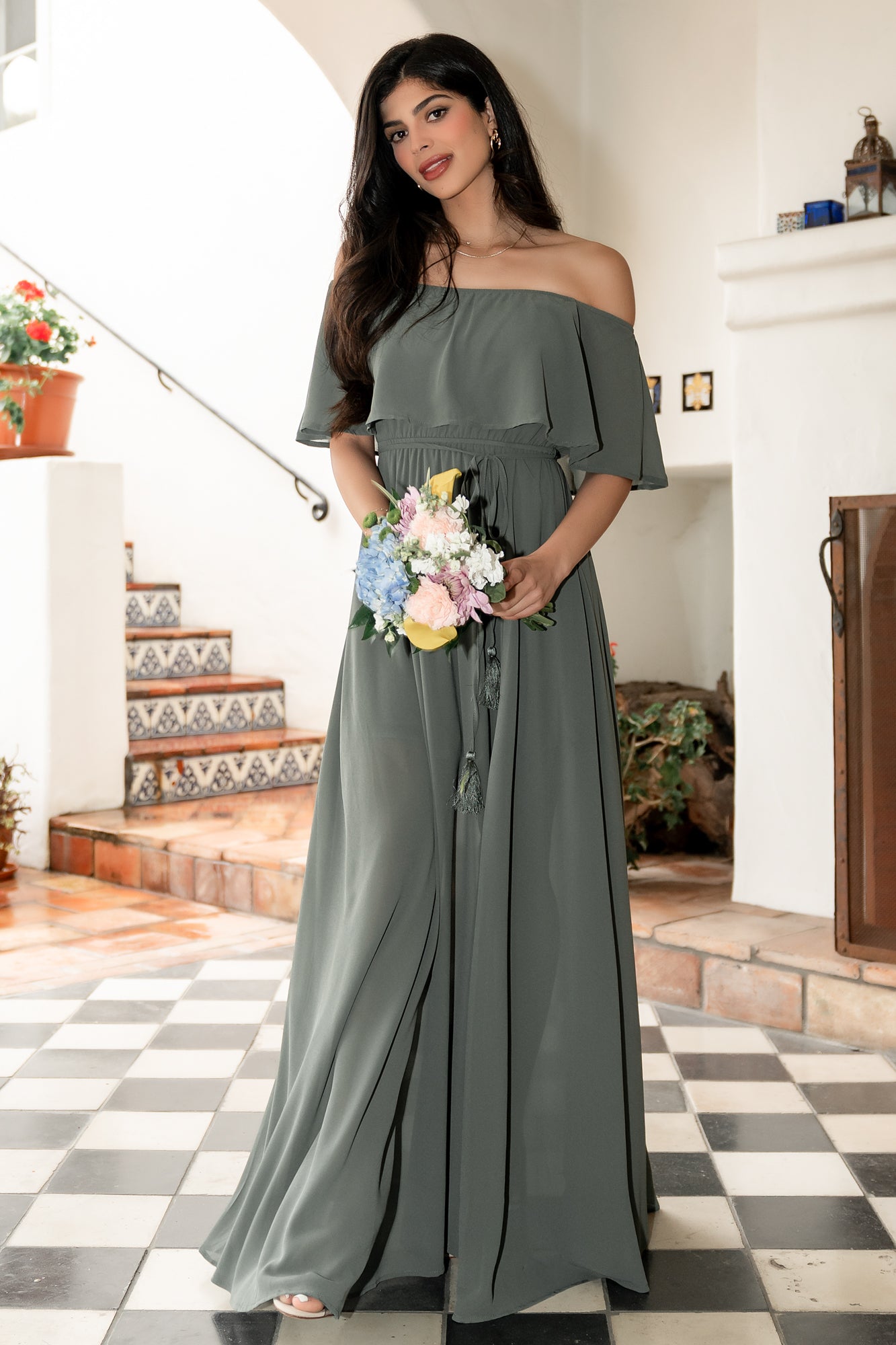 Side-angle view showing the left-side slit and mid-thigh lining beneath the sheer skirt layer on the dark sage maxi dress.