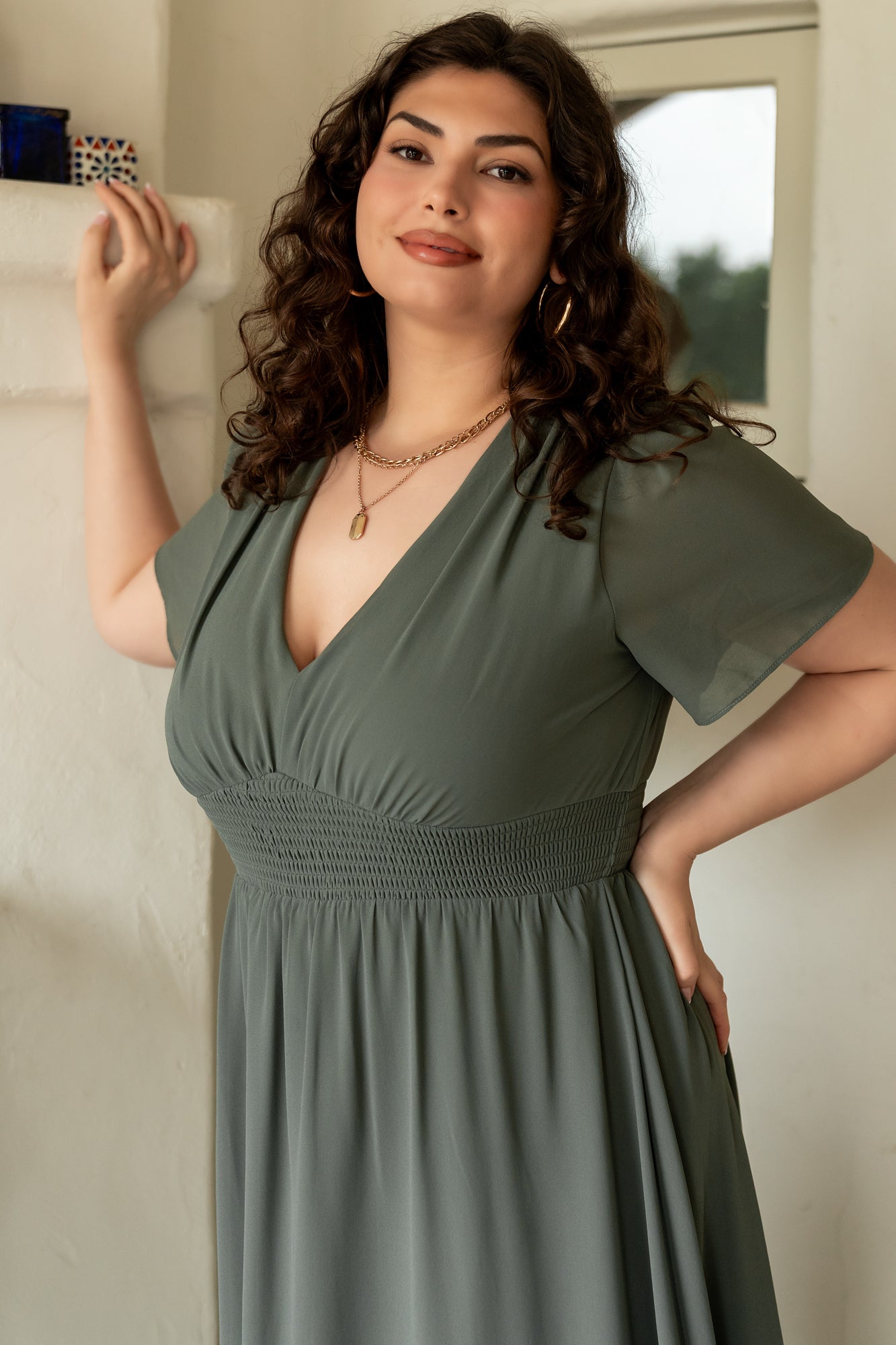 Styled flatlay of Birdie Maxi Dress in dark sage showing color, length and chiffon texture alongside suggested accessories.