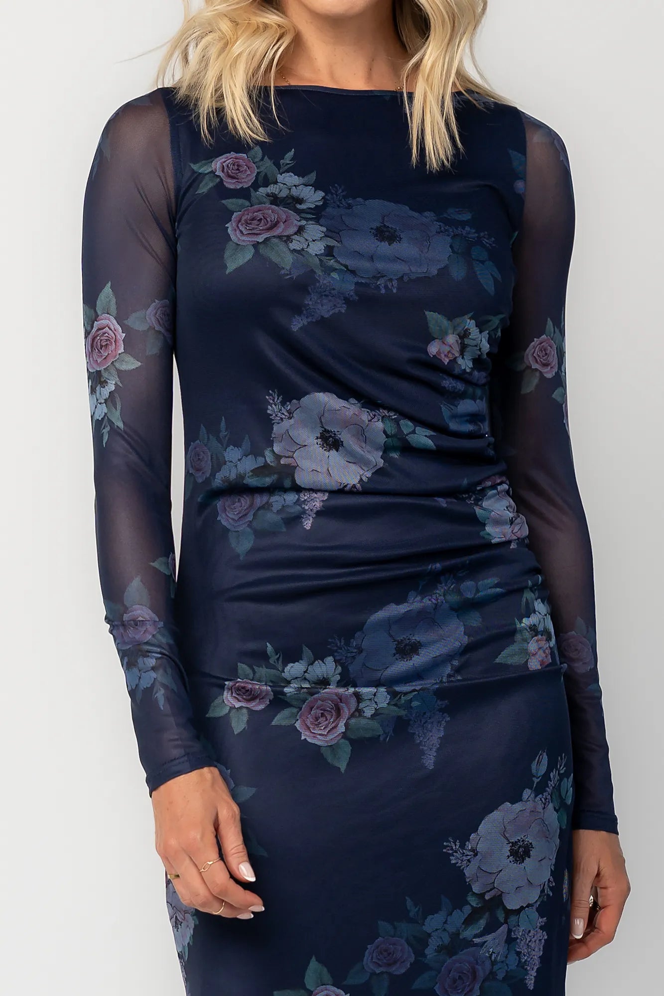 Model wearing a deep plum floral maxi dress with a fitted bodycon silhouette, sheer long sleeves, and a round neckline.