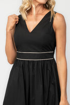 Model wearing a black midi dress with a V-neckline, tank straps, and a fitted bodice.