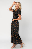 Model wearing a floral midi dress with a smocked bodice, wide V-neckline, and flutter sleeves.