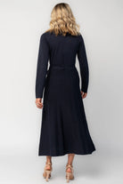 Model wearing a navy midi dress with a surplice V-neckline, long sleeves, and a matching waist tie