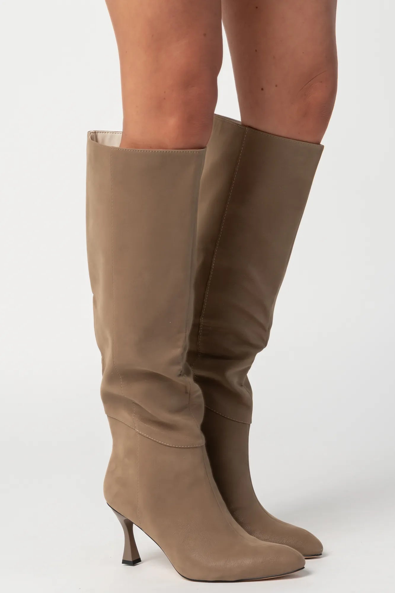Pair of mocha knee-high boots featuring a pointed toe, sleek fitted shaft, and sculpted kitten heel. The streamlined silhouette and smooth finish create an elegant, versatile look that pairs effortlessly with dresses, skirts, and tailored outfits.