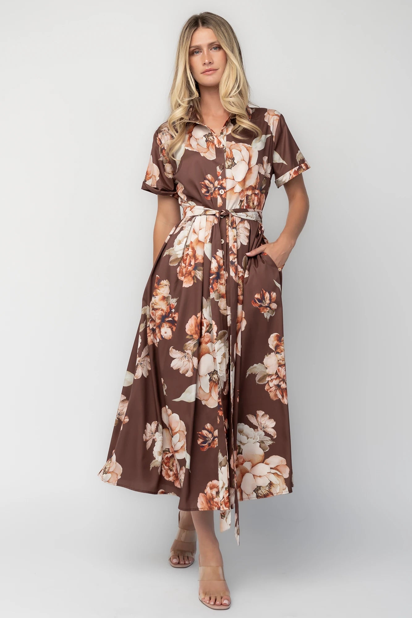 Model wearing the Blythe Midi Dress in Brown Floral featuring a collared neckline, functional button-front bodice, short rolled sleeves, and a removable waist tie.