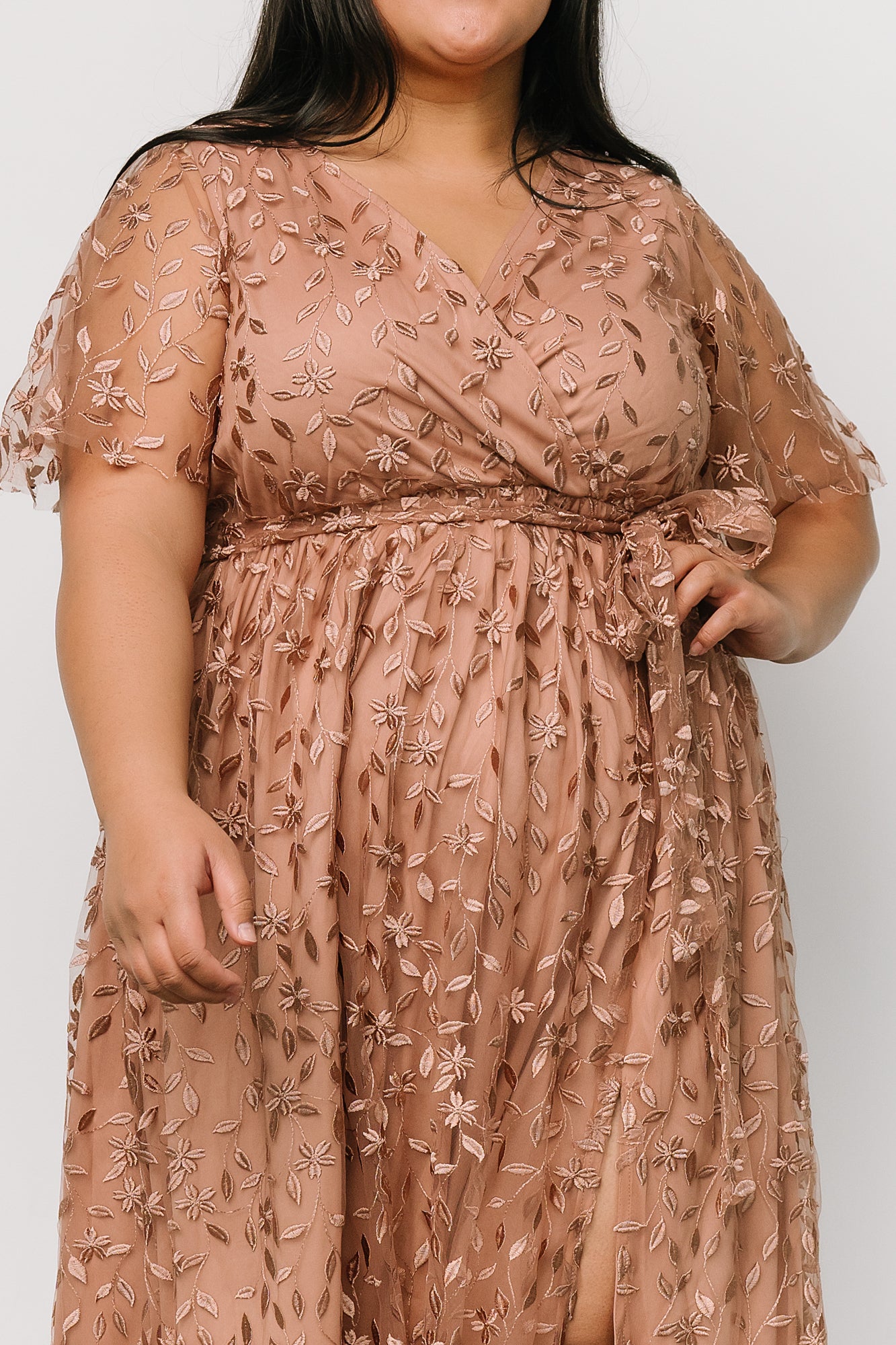 Styled flat-lay of the nude-rose embossed organza maxi dress with waist tie and delicate textured floral embossing on fabric.