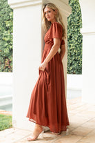 Full-length image of the cinnamon Birdie Maxi Dress displayed on a model, demonstrating the maxi hemline and soft chiffon movement.