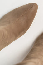 Close up of pair of mocha knee-high boots featuring a pointed toe, and sleek fitted shaft. The streamlined silhouette and smooth finish create an elegant, versatile look that pairs effortlessly with dresses, skirts, and tailored outfits.