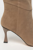 Close up of mocha knee-high boots featuring a sleek fitted shaft, and sculpted kitten heel. The streamlined silhouette and smooth finish create an elegant, versatile look that pairs effortlessly with dresses, skirts, and tailored outfits.