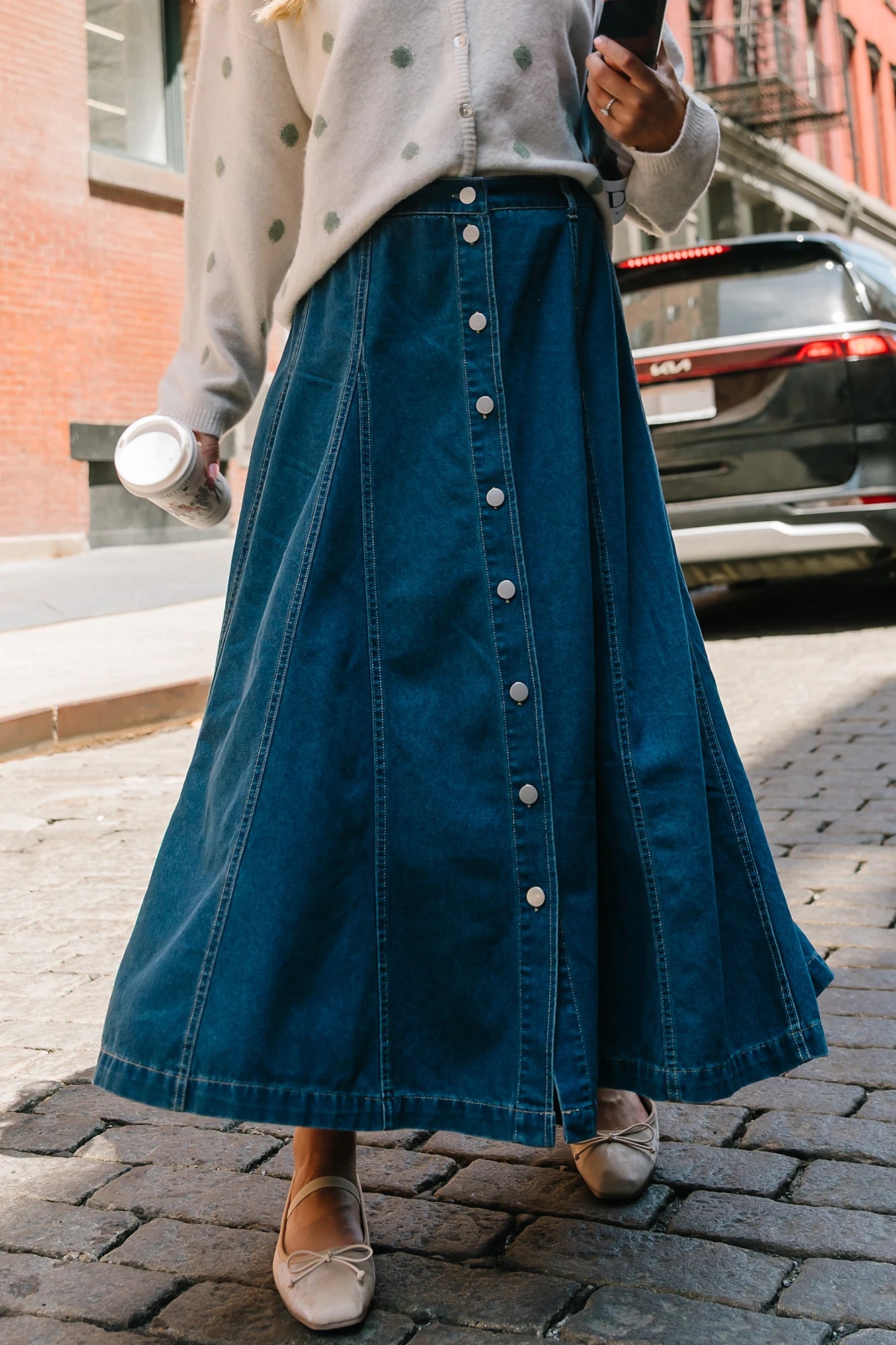 Model wearing the Cece Button-Down Denim Skirt in a dark wash featuring a button-front placket, elastic back waist, and a classic knee-length silhouette.