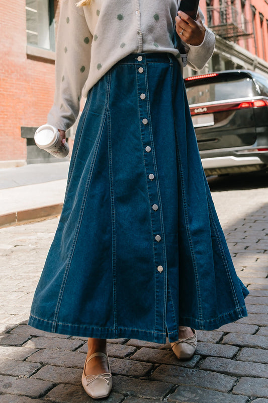 Model wearing the Cece Button-Down Denim Skirt in a dark wash featuring a button-front placket, elastic back waist, and a classic knee-length silhouette.