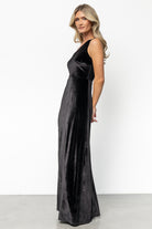 Detail shot of the mid-thigh slit and hem of the black velvet maxi, showing lining and edge finish.