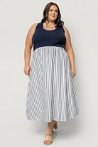 Model wearing Marbella Tank Midi Dress in navy stripe, highlighting ribbed bodice, elastic natural waist, and hidden side pockets.