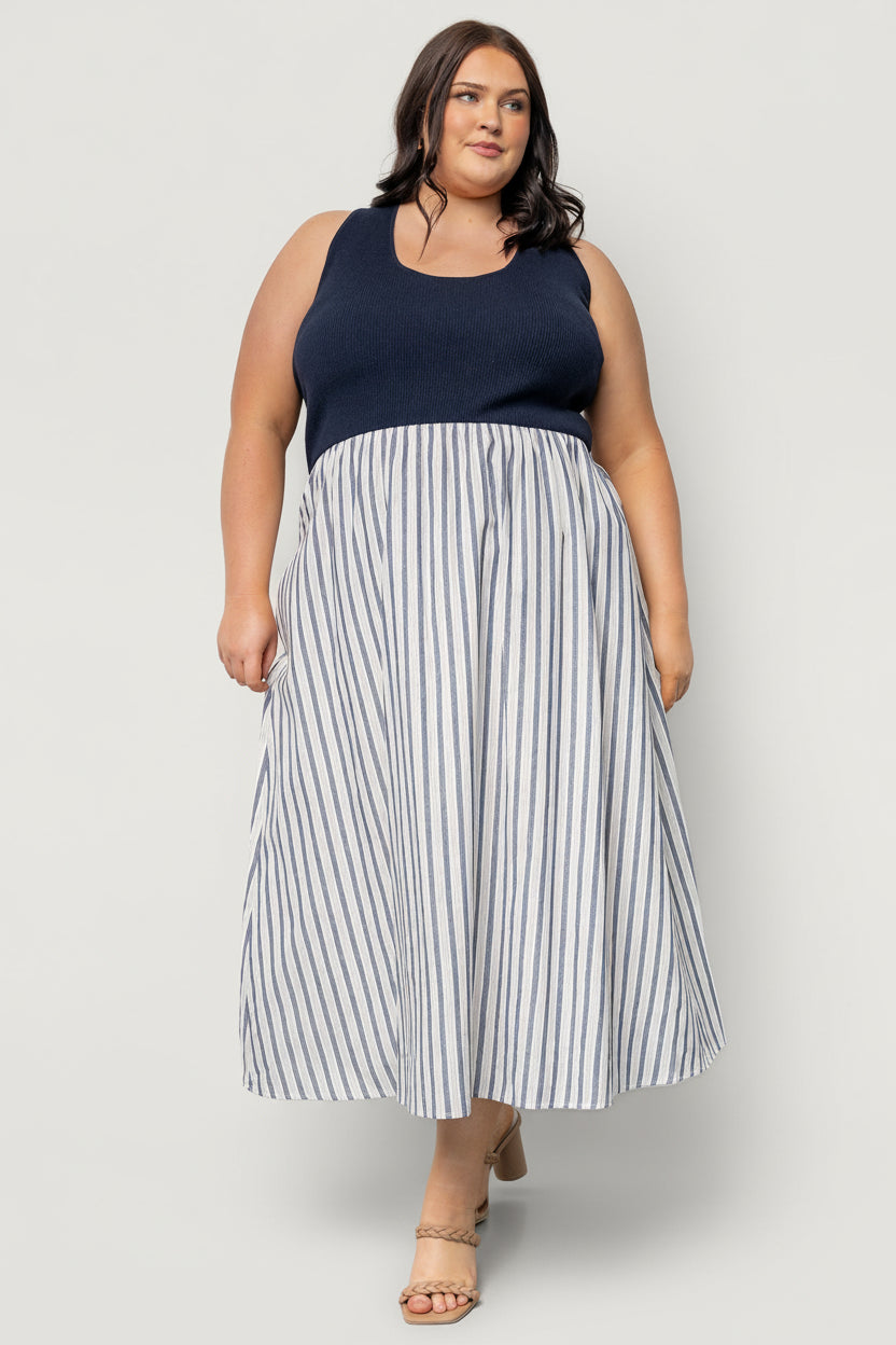 Model wearing Marbella Tank Midi Dress in navy stripe, highlighting ribbed bodice, elastic natural waist, and hidden side pockets.