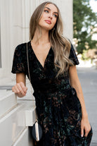 Model walking in Leslie Velvet Maxi Dress; shows movement of maxi skirt, short puff sleeves, and overall drape of the garment.