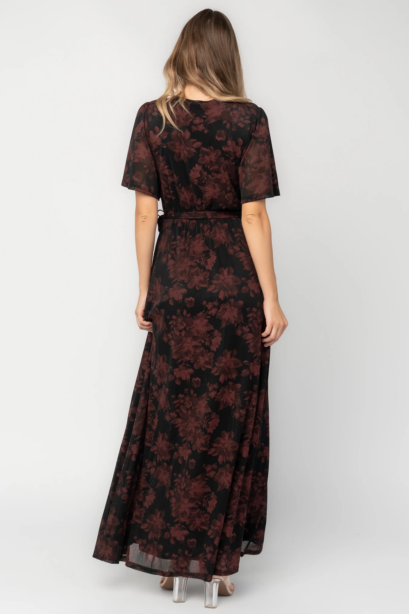 Black and burgundy floral shimmer maxi dress with flutter sleeves, surplice V-neck, elastic waist, removable sash, and side leg slit.