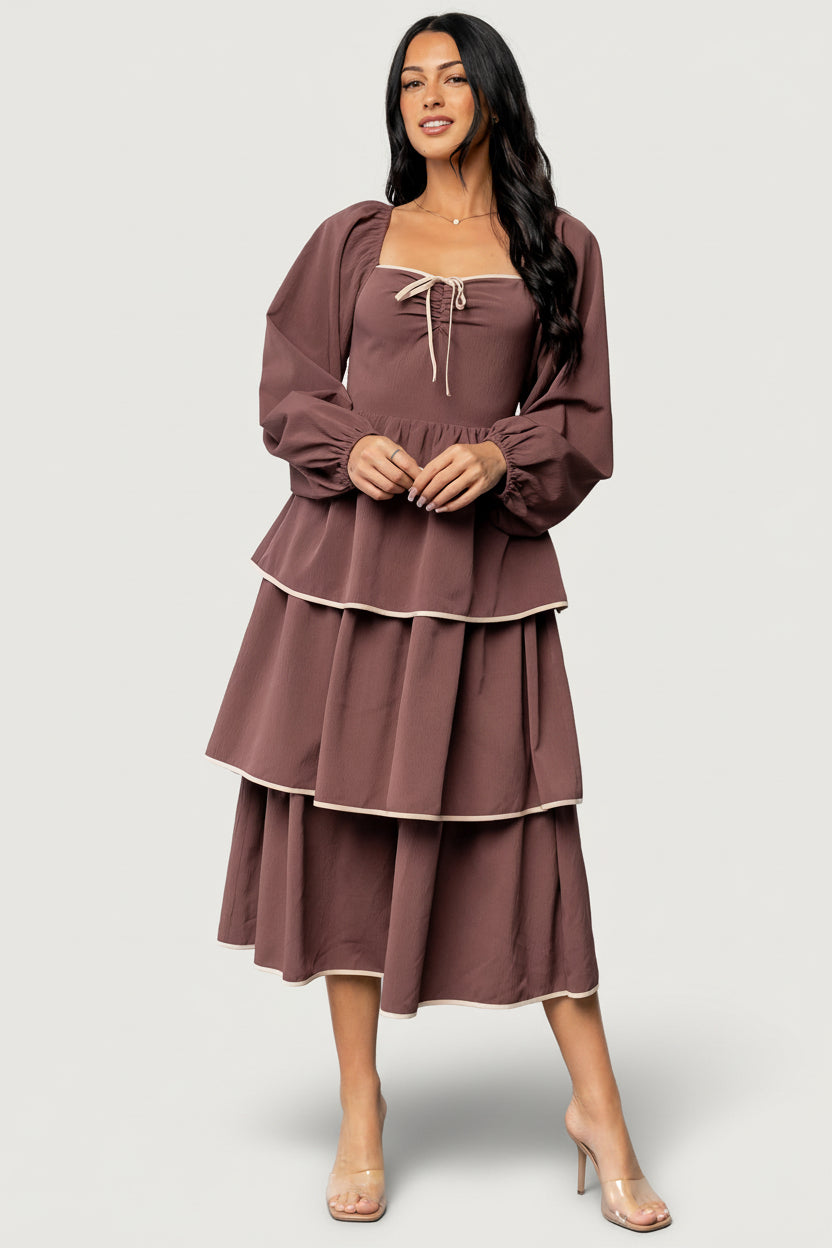Fabric and trim close-up showing lightweight polyester drape and ivory contrast along tier edges of the vintage plum dress.