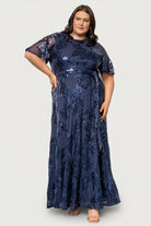 Close-up of navy sequin leaf detail and short sheer sleeve showing texture, sequins, and delicate fabric contrast with the lining.