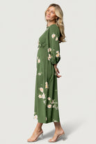 Styled shot of the Karalie Maxi Dress in green floral, showing overall fit, print scale, and how the smocked waist shapes the silhouette.