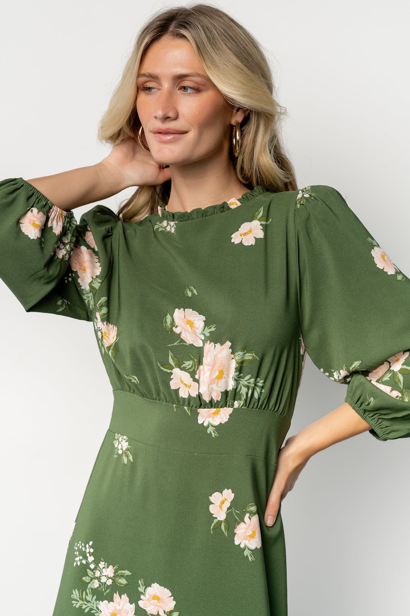 Fabric close-up of the green floral print on chiffon for the Karalie Maxi Dress, showing light-pink floral details and fabric texture.