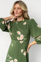 Fabric close-up of the green floral print on chiffon for the Karalie Maxi Dress, showing light-pink floral details and fabric texture.
