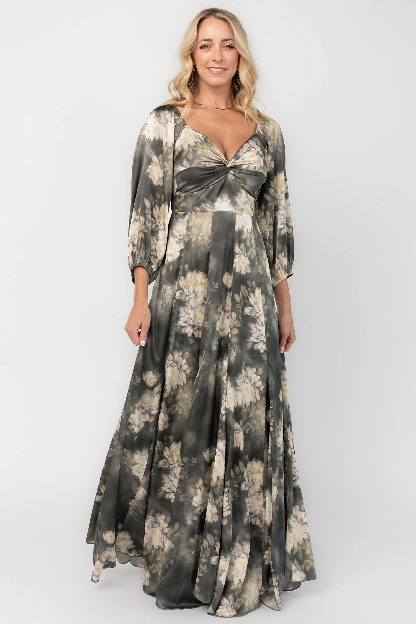 Dark sage floral maxi dress with a V-neck twist knot, half sleeves, smocked back waist, paneled empire waist, and flowing scalloped asymmetrical hem.