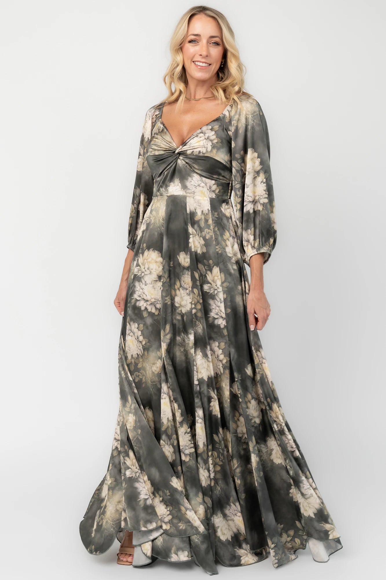 Dark sage floral maxi dress with a V-neck twist knot, half sleeves, smocked back waist, paneled empire waist, and flowing scalloped asymmetrical hem.
