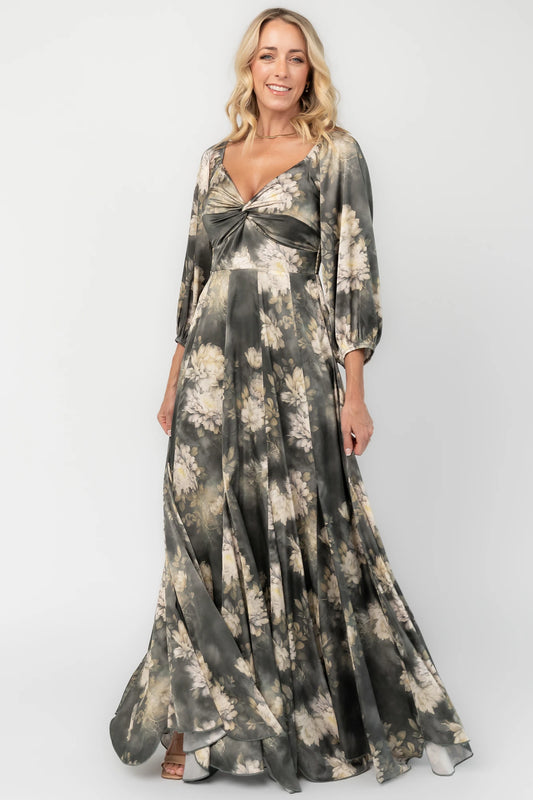 Dark sage floral maxi dress with a V-neck twist knot, half sleeves, smocked back waist, paneled empire waist, and flowing scalloped asymmetrical hem.